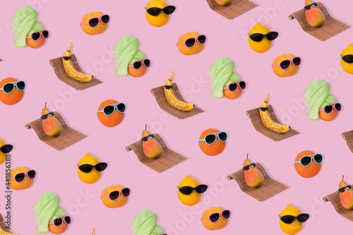  Creative idea pattern made from various tropical fruits. Banana, pear, orange, lemon and grapefrruit hipster in sunglasses on pink background.