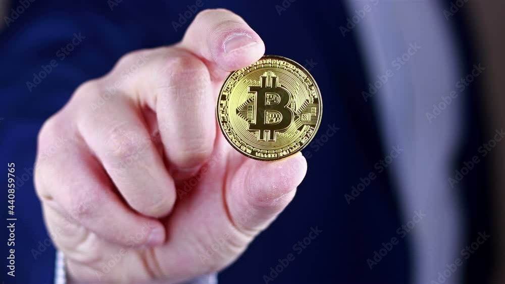 Businessman holds Bitcoin in his hand. Businessman holds Bitcoin in his hand.
