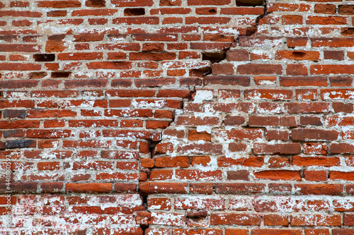 Old red brick wall with a large crack
