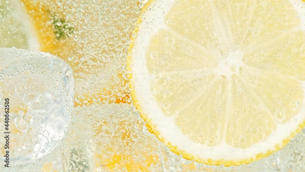 Super Slow Motion Shot of Fizzing Water with Lemon Slices and Ice Cubes in Glass at 1000 fps.