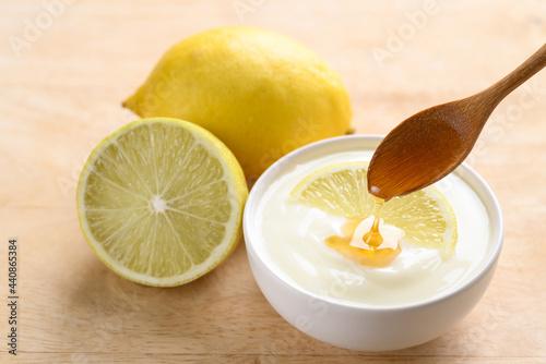 Fresh lemon and yogurt in a bowl with spoon pouring honey, Healthy eating and beauty skincare