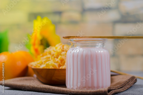 yogurt with natural glutem-free wheat cereal, with fresh orange fruits in a glass cup and a wooden bowl. with copyspace room for text. Greek photo