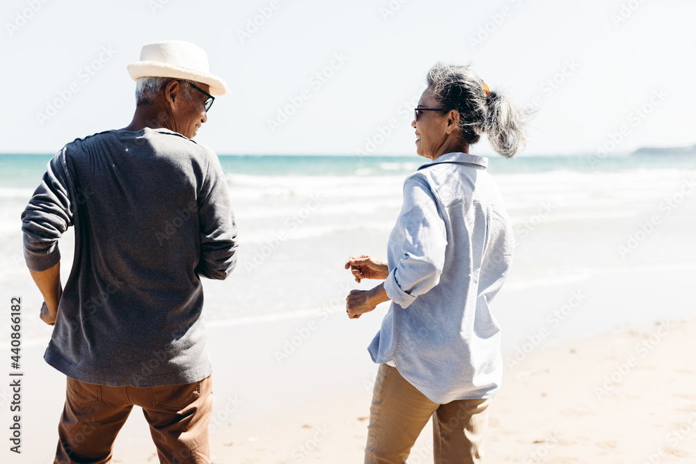 Retired couple happily running on the beach.Plan life insurance and retirement concept. Retired couple happily running on the beach.Plan life insurance and retirement concept.