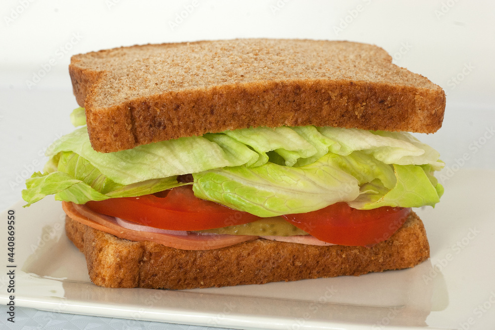 whole grain sub style cold cuts sandwich with sliced ham pepperoni and salami topped with cheese tomato lettuce pickle olives whole grain sub style cold cuts sandwich with sliced ham pepperoni and salami topped with cheese tomato lettuce pickle olives