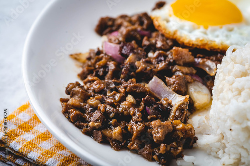 SisigSilog- is a typical Filipino Breakfast meal, consisting usually of sisig (a dish made from parts of a pig's face and belly, and chicken liver) , fried egg and fried rice photo