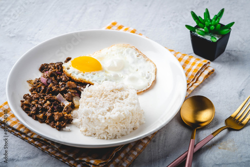 SisigSilog- is a typical Filipino Breakfast meal, consisting usually of sisig (a dish made from parts of a pig's face and belly, and chicken liver) , fried egg and fried rice photo