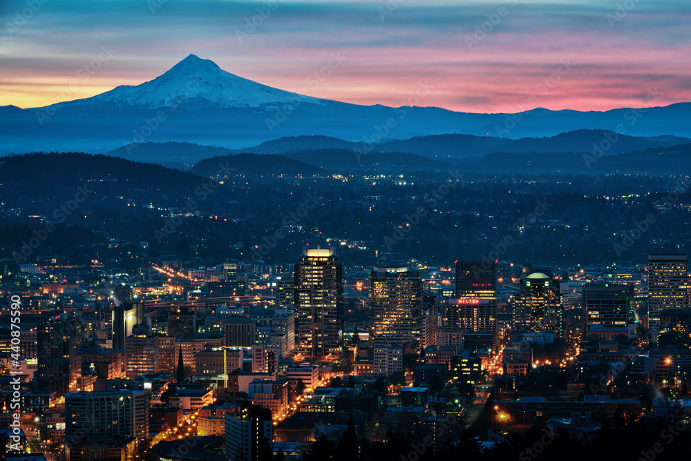 A colorful cityscape sunrise with Mt Hood and the city lights of Portland, Oregon