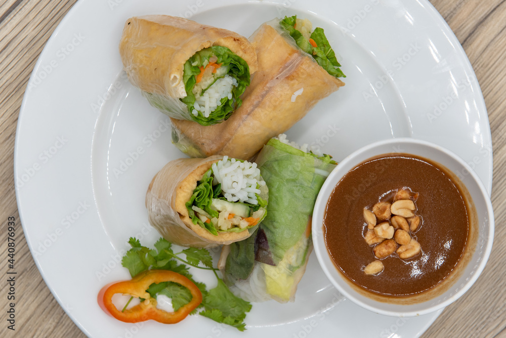 Overhead view of hearty plate of tofu spring rolls cut in halves for a complete meal