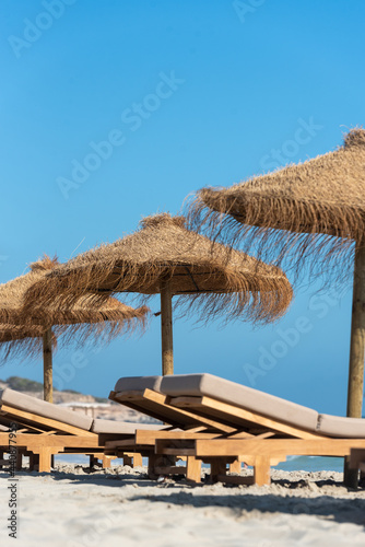 Fototapeta Naklejka Na Ścianę i Meble -  Deck chairs and straw umbrellas on the wonderful island of Formentera in Spain