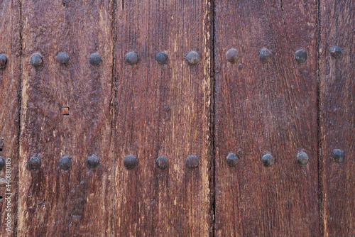 Textura de madera vieja de ventanas y puertas desgastadas por el tiempo con grietas y clavos oxidados