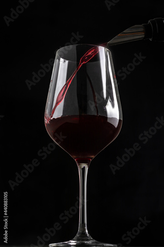 pouring wine into a glass with a black background