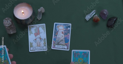 A hand flipping over Tarot cards during a reading with healing crystals photo