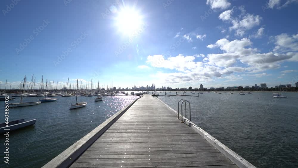 Wooden pier and docked sailboats in St Kilda , city horizon, dolly forward Wooden pier and docked sailboats in St Kilda , city horizon, dolly forward