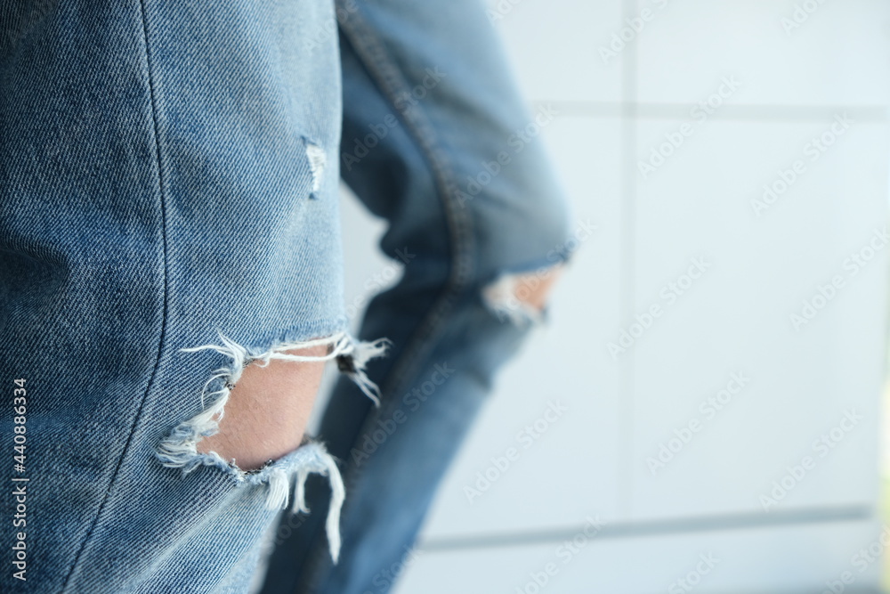 close-up of a man in torn jeans. Blue, old, fashionable, shabby. On a white background. Italian fashion. close-up of a man in torn jeans. Blue, old, fashionable, shabby. On a white background. Italian fashion.