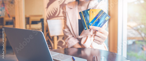 Women hold three credit cards to shop online.