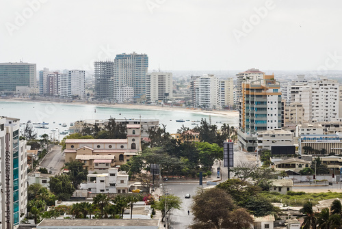 View of the boardwalk, the beach, buildings and streets of the coastal city. Horizontal photo.