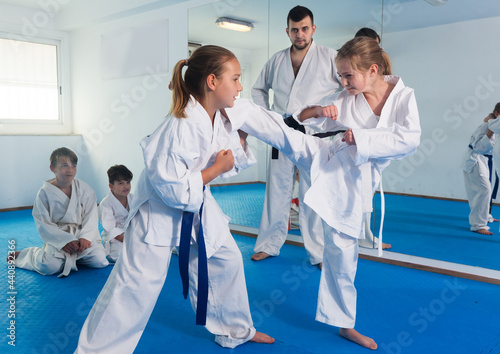 Young girls training in pair to use new techniques during karate class