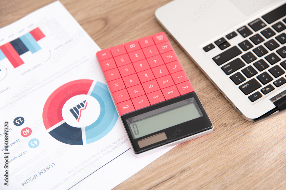 Financial documents and calculator and laptop Financial documents and calculator and laptop