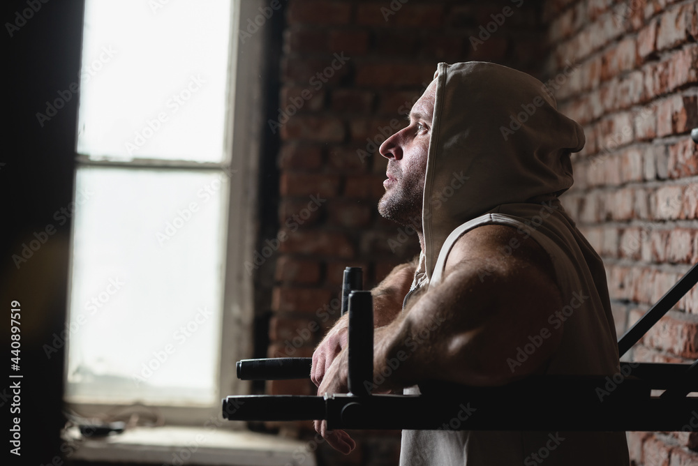 Bodybuilder man is posing in the gym.