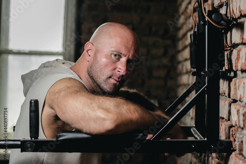 Bodybuilder man is posing in the gym.