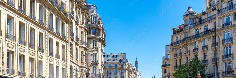 Paris, beautiful Haussmann facades in a luxury area of the capital, with the Eiffel Tower in background
