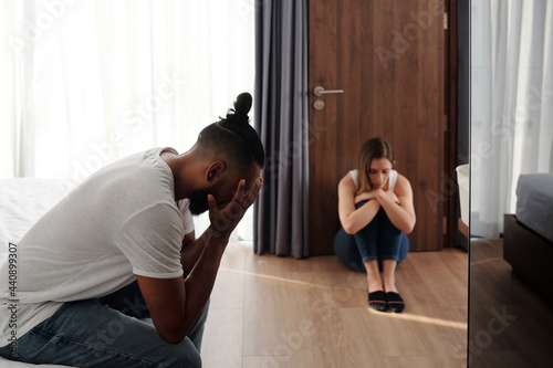 Unhappy offended husband and wife sitting in bedroom apart from each other after big quarrel or fight, divorce and relationship problems concept © DragonImages