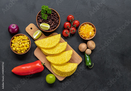 Preparing to cook vegetarian tacos with mushrooms, beans, peppers, corn, and cheese.