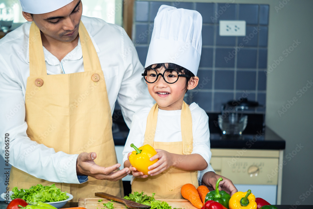 Asian woman young mother with son boy cooking salad food with vegetable holding tomatoes and carrots, bell peppers on plate for happy family cook food enjoyment lifestyle kitchen in home Asian woman young mother with son boy cooking salad food with vegetable holding tomatoes and carrots, bell peppers on plate for happy family cook food enjoyment lifestyle kitchen in home