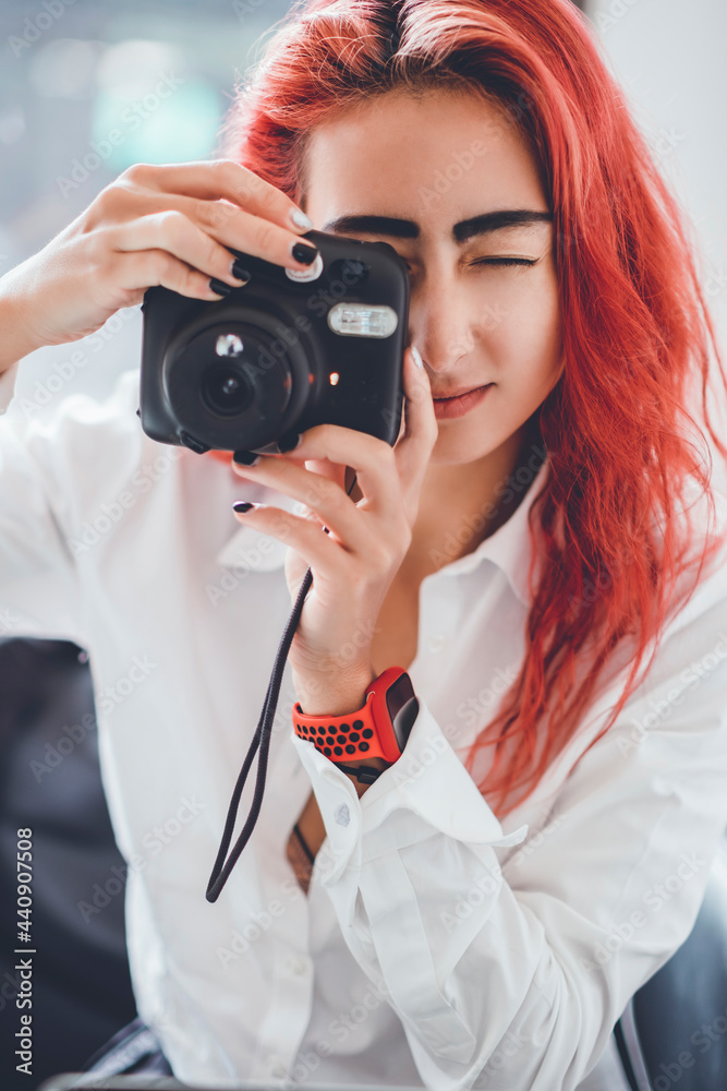 Young girl make photo on film camera, shoot happy, hair red color, smart watch, cafe Young girl make photo on film camera, shoot happy, hair red color, smart watch, cafe