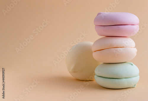 Closeup of sweet marshmallows on the cream color background with text space on the left.