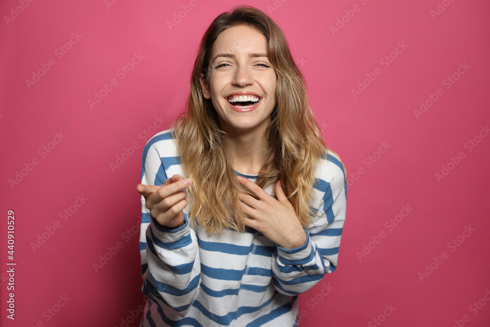 Cheerful young woman laughing on pink background Cheerful young woman laughing on pink background