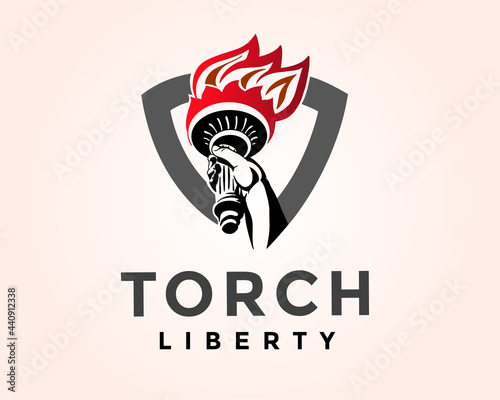 Hand take torch flame liberty shield logo design template illustration