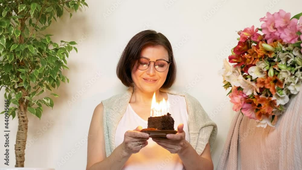 Mature beautiful woman with small birthday cake with burning candles Mature beautiful woman with small birthday cake with burning candles