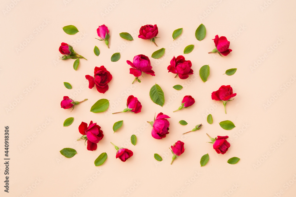 Flat lay, copy space. Summer composition with flowers roses and leaves on a beige background. Flat lay, copy space. Summer composition with flowers roses and leaves on a beige background.
