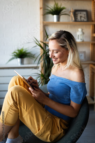 Happy young woman using tablet pc in loft apartment