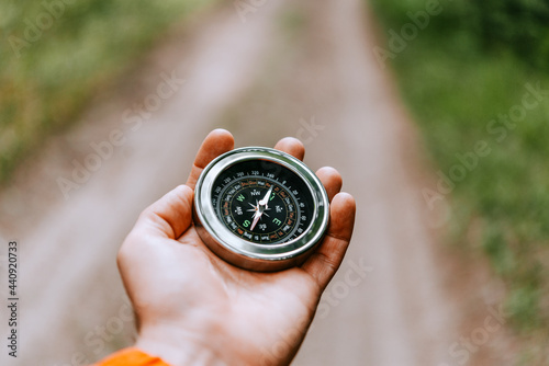 A man holds a compass in hand and is guided by the area, autumn forest, walk,hiking