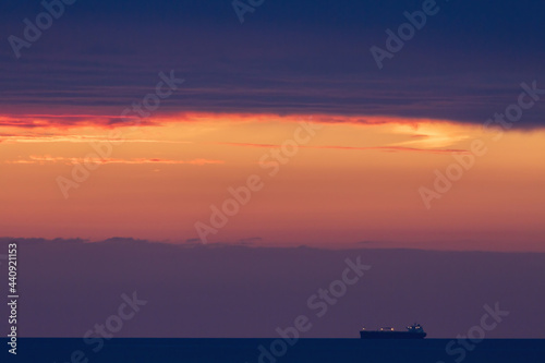Sunset over the Irish Sea from Penmaenmawr, Wales with a silhouette containers ship on the horizon. Concept is Peace and serenity