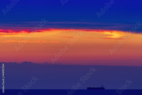 Sunset over the Irish Sea from Penmaenmawr, Wales with a silhouette containers ship on the horizon. Concept is Peace and serenity