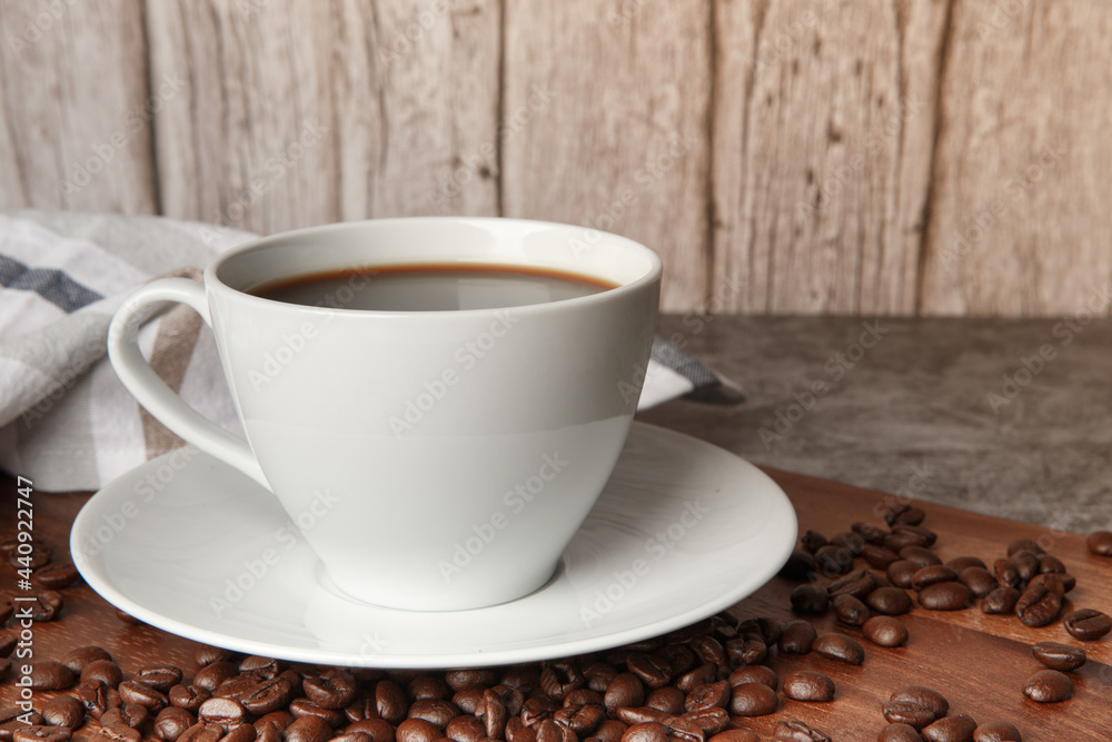 Fototapeta premium Cup of coffee and coffee beans on old wooden background