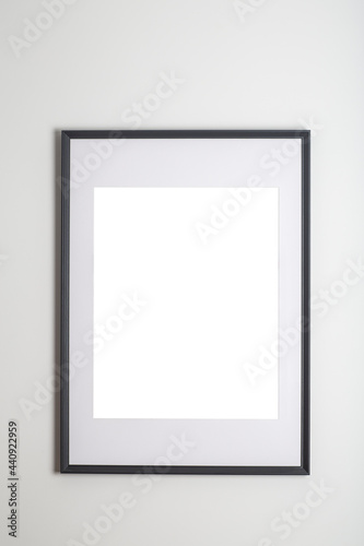 Mock up poster frame in interior white wall. White frame for poster or photo image on clean wall in home room or office interior © uladzimirzuyeu