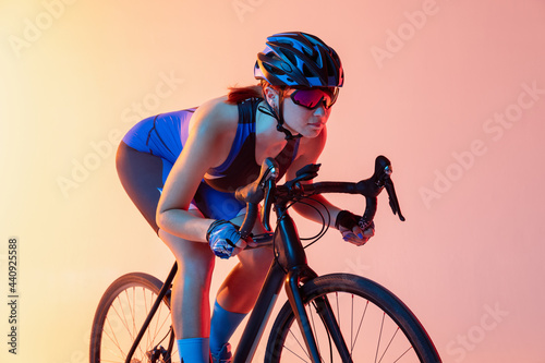 Cyclist riding a bicycle isolated against neon background