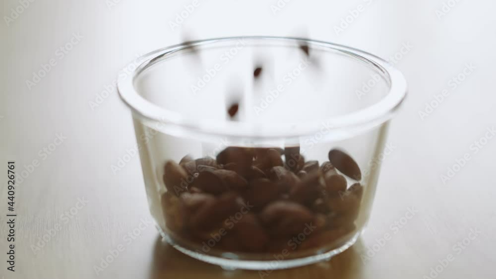 Brown almonds falling down in to bowl. product rich in minerals and vitamins. Slow motion. Brown almonds falling down in to bowl. product rich in minerals and vitamins. Slow motion.