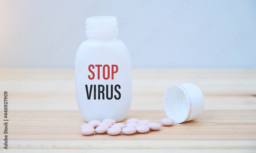 STOP VIRUS text on a medicine jar with scattered pills