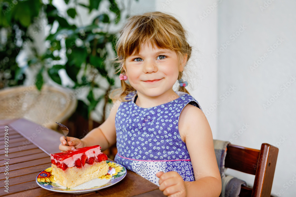 Little preschool girl with strawberry cake. Happy child eating cake with fresh strawberries. Summer dessert for families. Little preschool girl with strawberry cake. Happy child eating cake with fresh strawberries. Summer dessert for families.