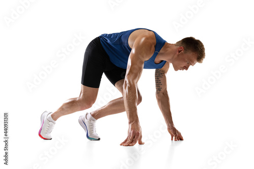 Caucasian professional male athlete  runner training isolated on white studio background. Muscular  sportive man. Concept of action  motion  youth  healthy lifestyle. Copyspace for ad.