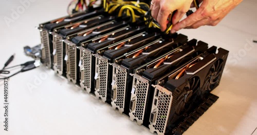 Hands one by one take out the wires and take out the video cards from the motherboard in connection with the prohibition of cryptocurrency mining