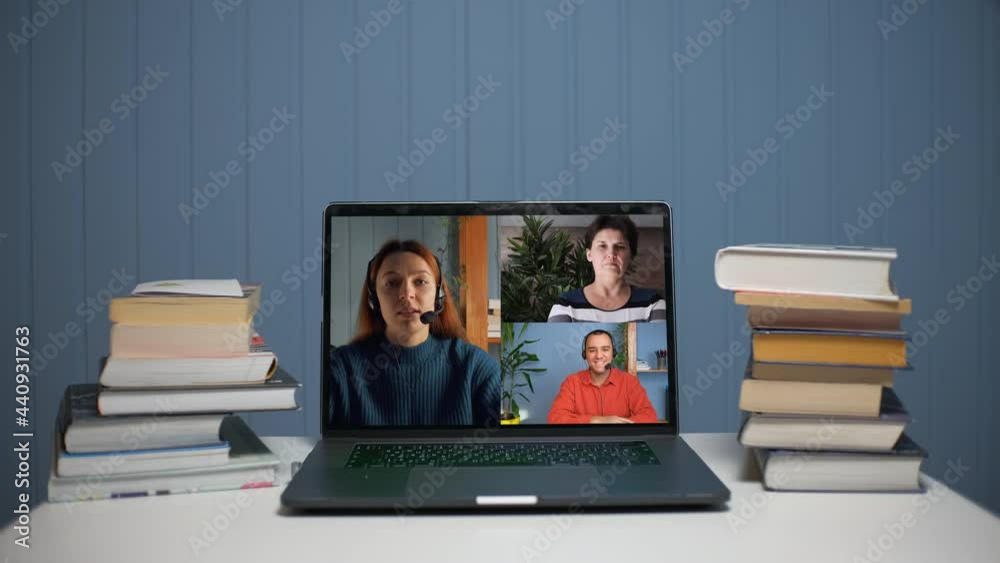 A young woman is talking on a video call with a young man and a woman. A young woman teaches online through video communication. A young woman is talking on a video call with a young man and a woman. A young woman teaches online through video communication.