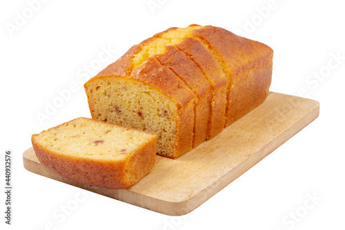 Sliced pound cake with lemon glaze on a cutting board isolated on a white background.