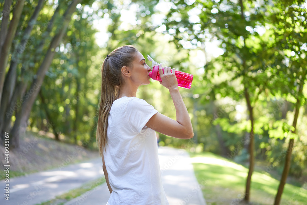 Woman drink water red bottle after morning workout. Woman drink water red bottle after morning workout.