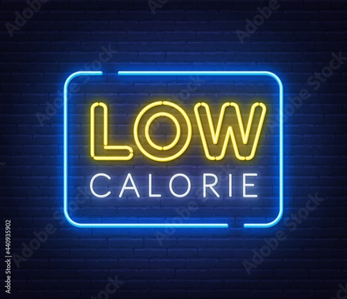 Low Calorie neon sign on brick wall background.